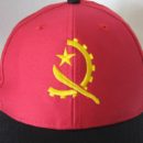 Casquette rouge, visière noire, logo brodé jaune, ambassade Angola